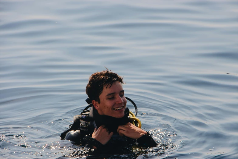 a man wearing a scuba suit and holding soing in his chest