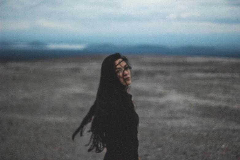 a young woman walking across a field holding onto a frisbee