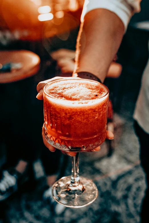 a man making drinks out of a wine glass