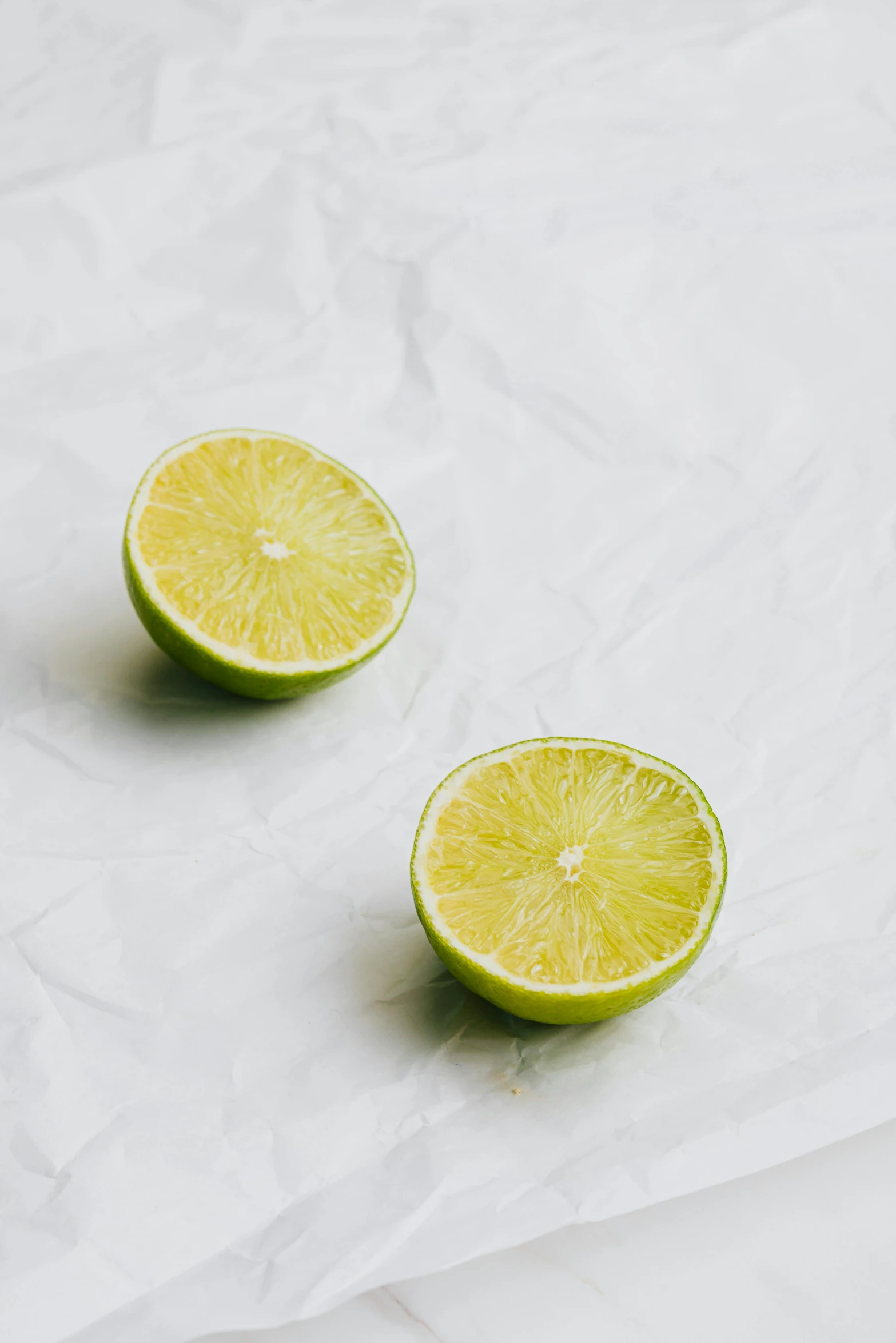 two slices of lime sit in the middle of white paper