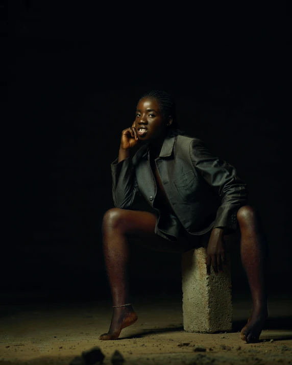 a woman sitting on a block in a dark room