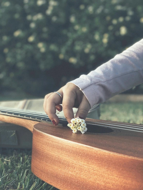 a person touching the top of a guitar