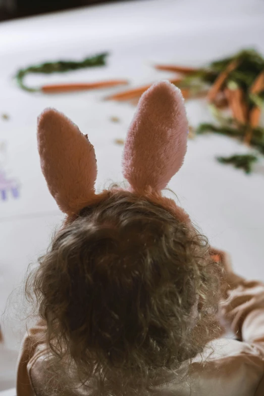 a child's back with bunny ears is seen from behind