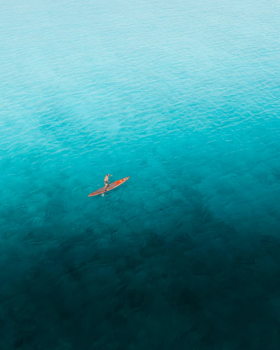 a single person paddle surfing across an ocean