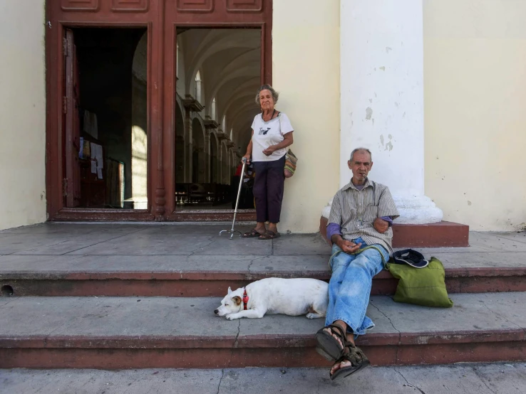 two people on stairs with a dog sitting next to them