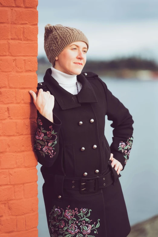 a woman posing for a pograph with a brick wall