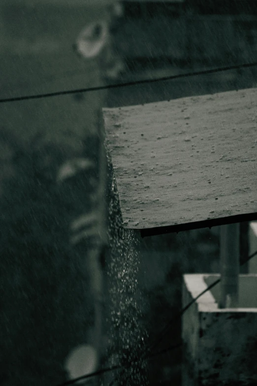 a close up of rain falling from a roof