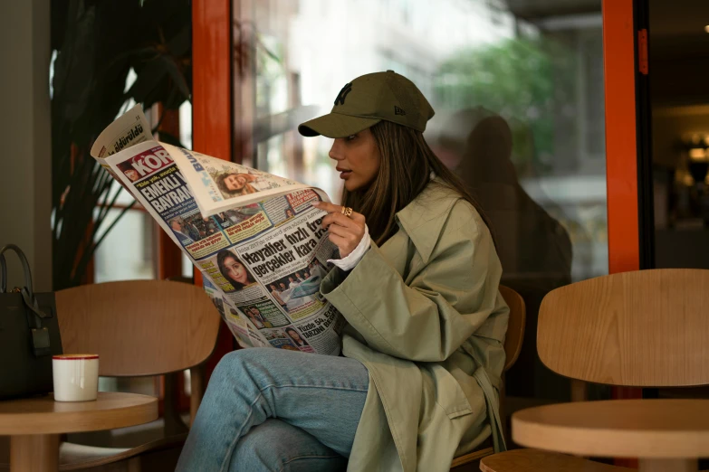 the person is reading the paper on her lap