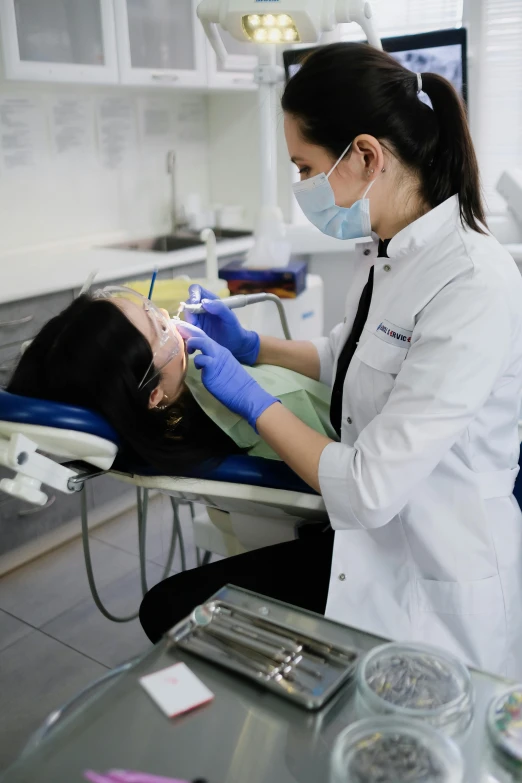 the woman is getting her teeth checked by the dentist