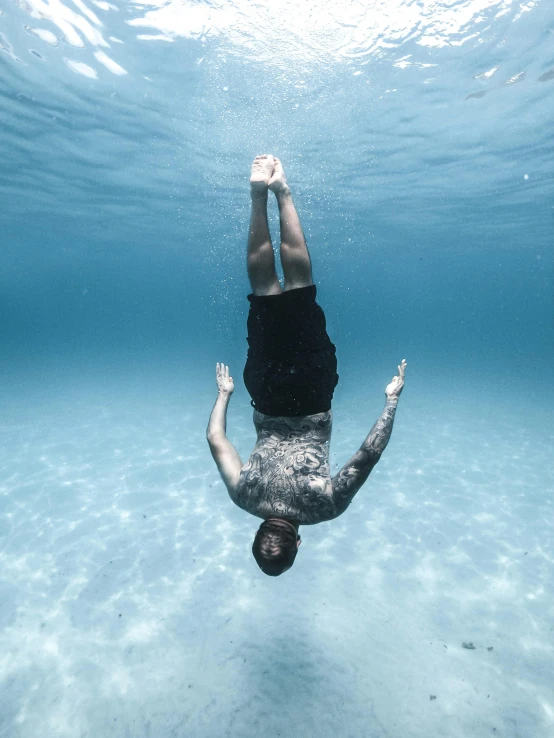 a person diving underwater with clear blue water