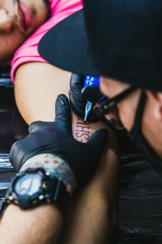 a man drawing on someones arm with a marker