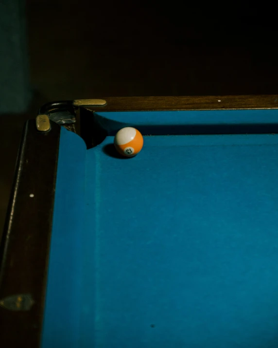 an orange and white billiard ball is in the air