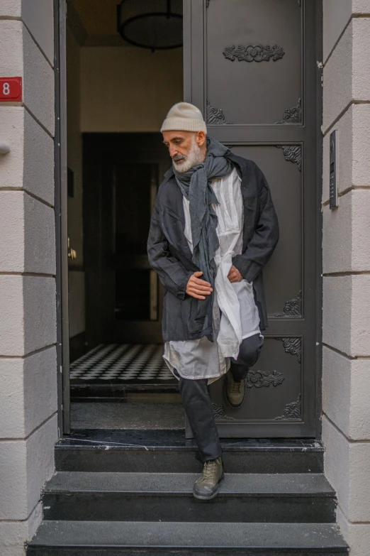 old man stepping off the door of a building