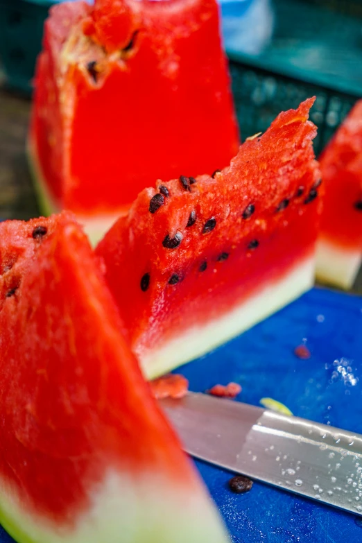 slices of watermelon and a knife on a  board