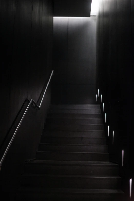 a dark staircase leading to the sky with lights above