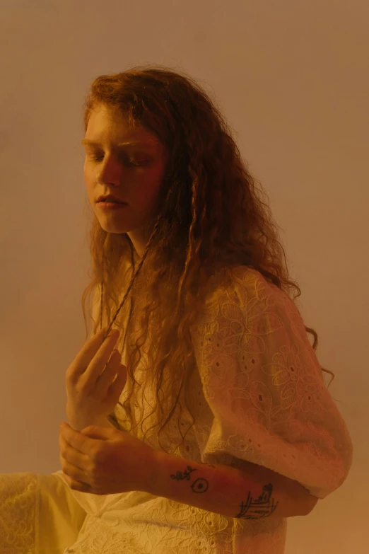 a woman with long red hair sitting on a table