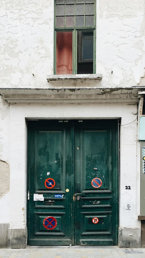 a two green doors next to a building