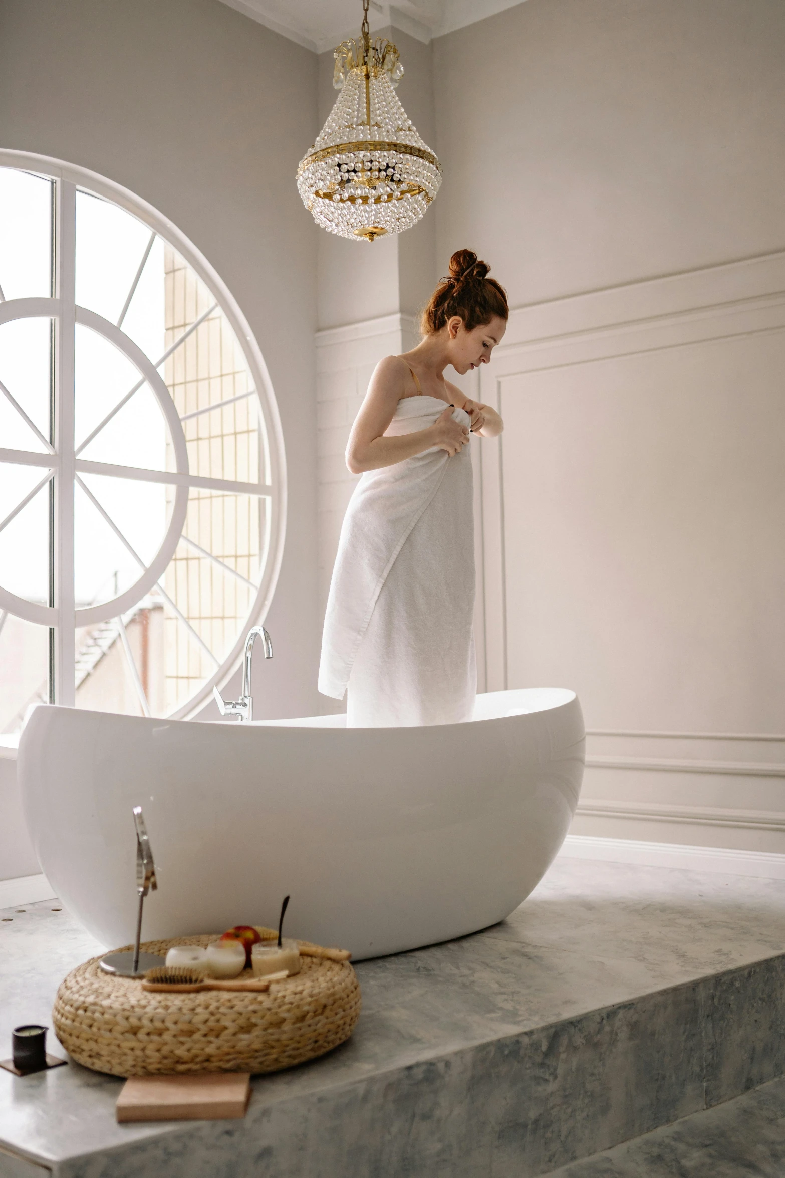 a woman standing in the bath room, and checking her phone