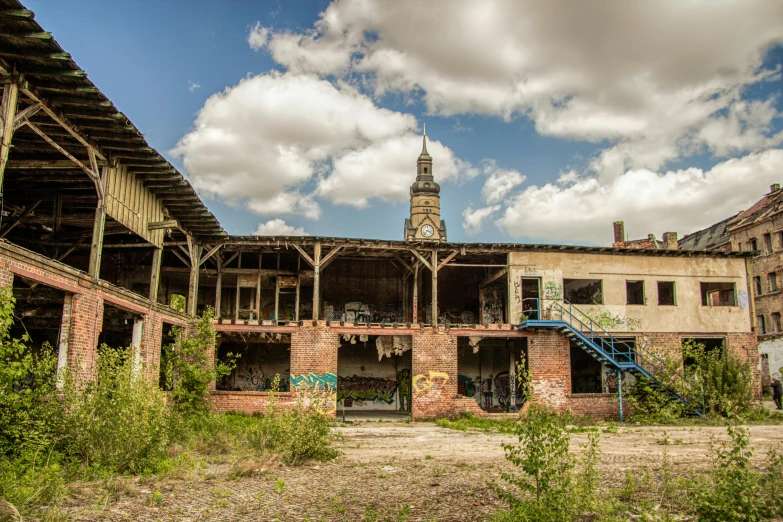 an abandoned building with a clock tower in the background