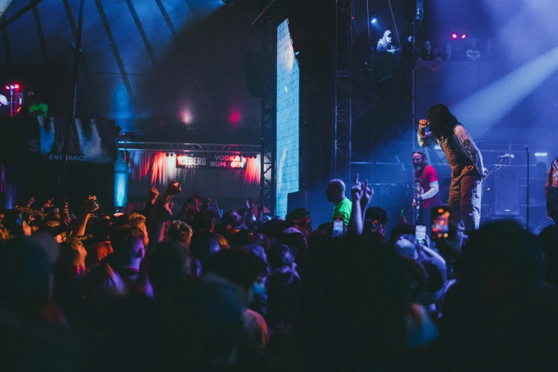 two people standing on stage and holding hands in front of them