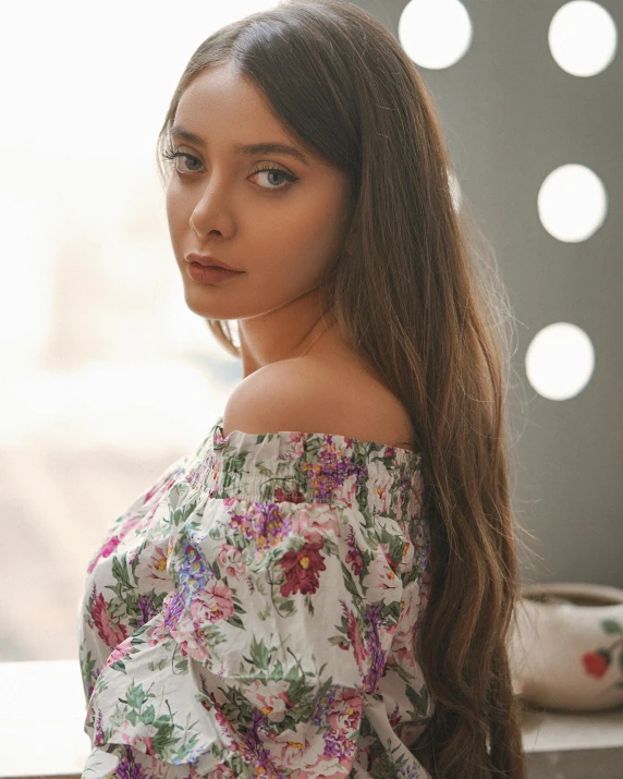 young woman with very long hair leaning against window