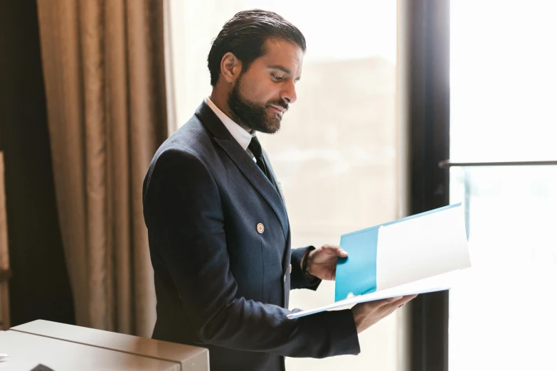 a man wearing a suit with papers in his hand