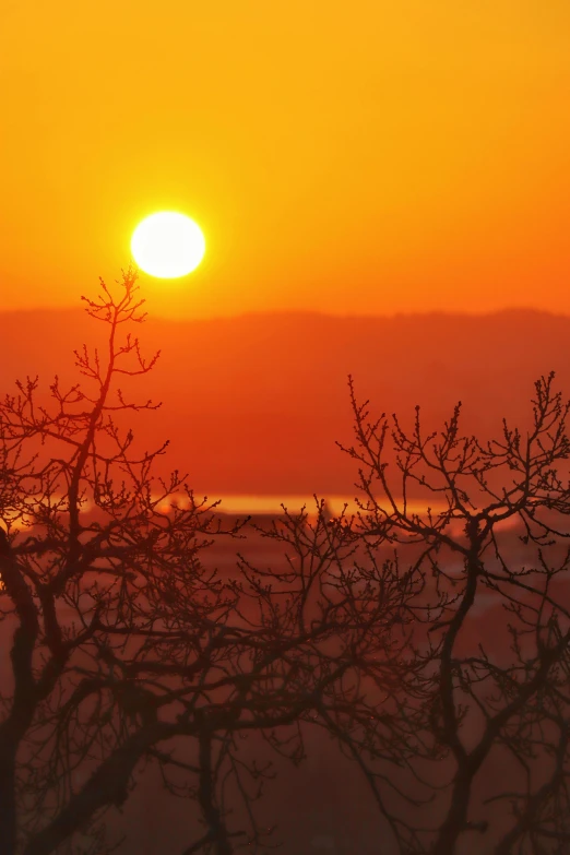 the sun rising behind a distant mountain range