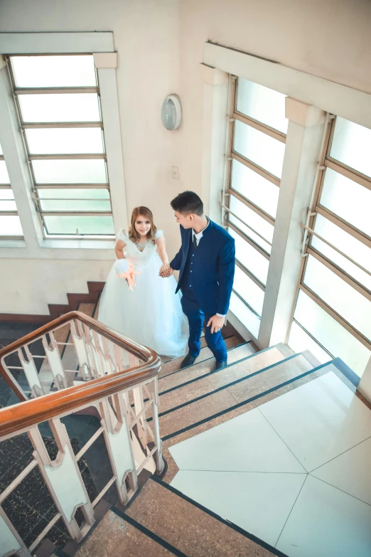 a couple are walking up the stairs in their wedding clothes