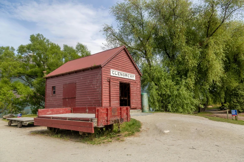 an old red building with a bench on the front