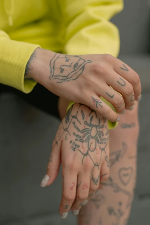 person with tattooed arms with tattoos on them sitting down