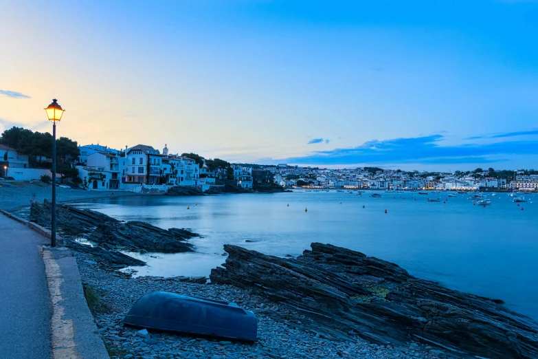 a beach and the water at dusk with people on it