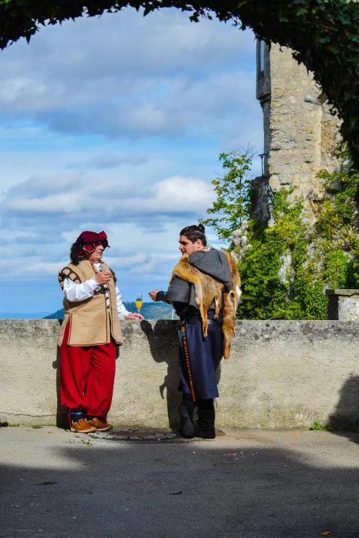 two people stand near a wall and exchange a text