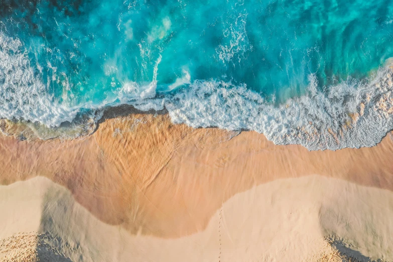 a beach with waves, sand and a body of water