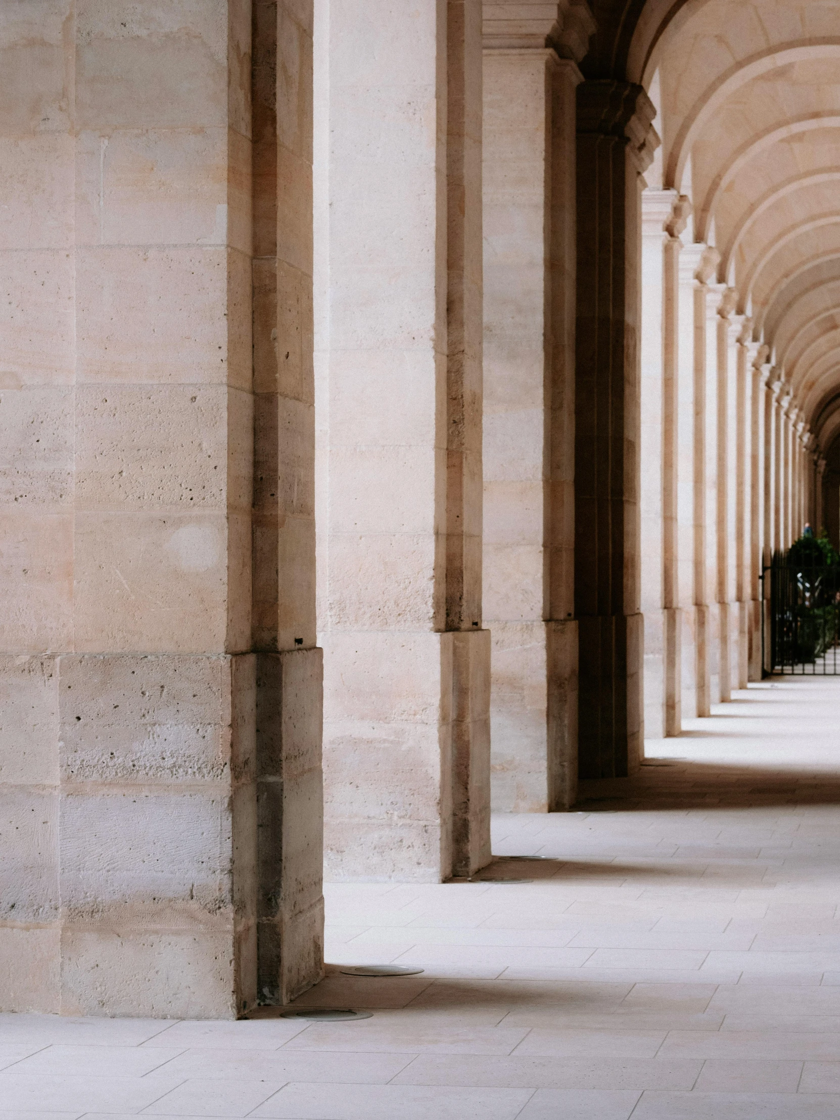 long tunnel covered in columns in the middle of an open area