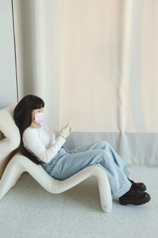 a woman sitting on a chair with a pillow and mask