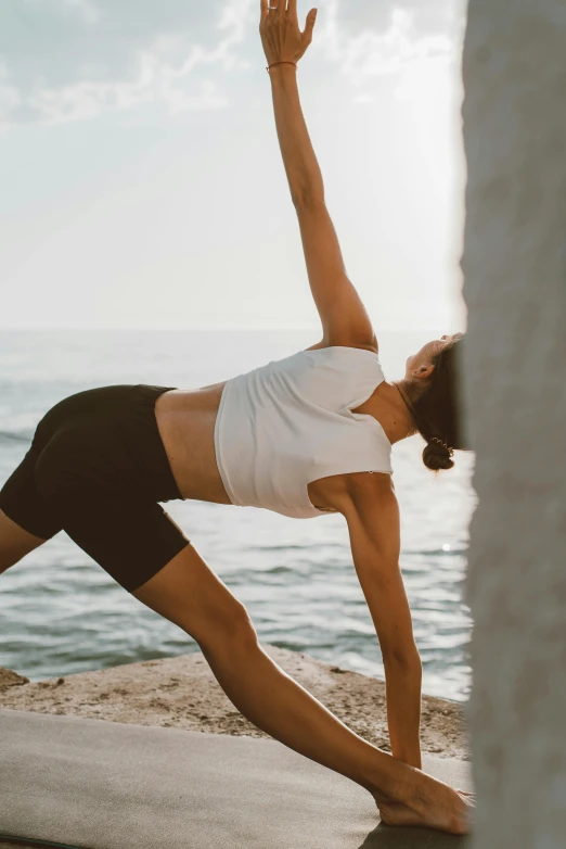 a woman doing yoga on top of a stone wall