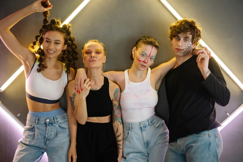 the women are posing in front of a neon light