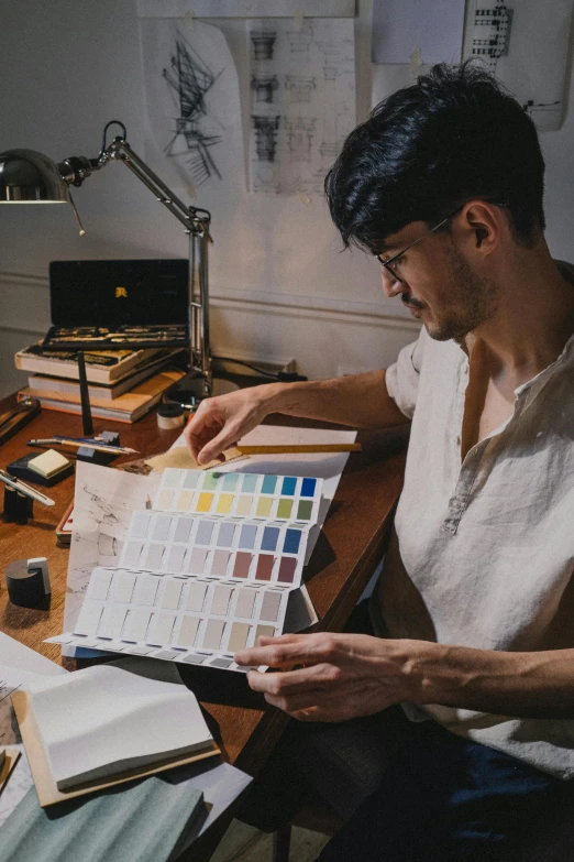 man with eyeglasses working on a piece of paper