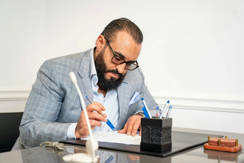 a man sitting at a desk with pen and notebook