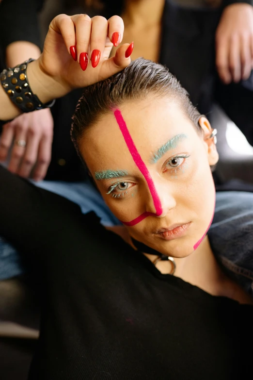 a woman is sitting down with a pink tape across her face