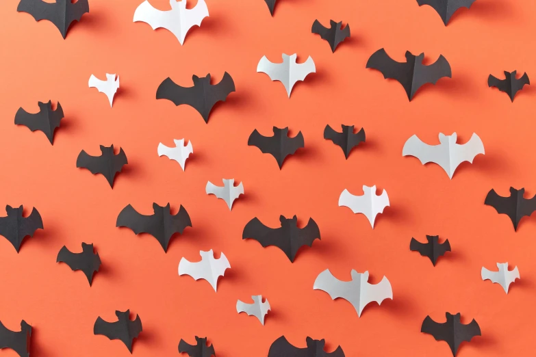 paper bats and bats cut out on an orange background