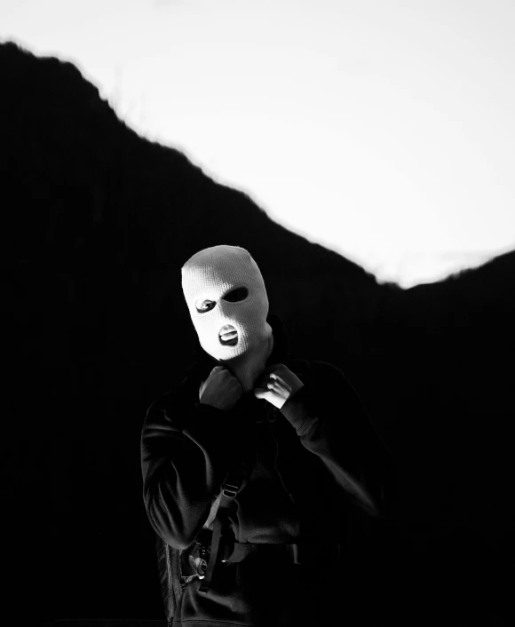 the person in the black and white mask poses for a picture