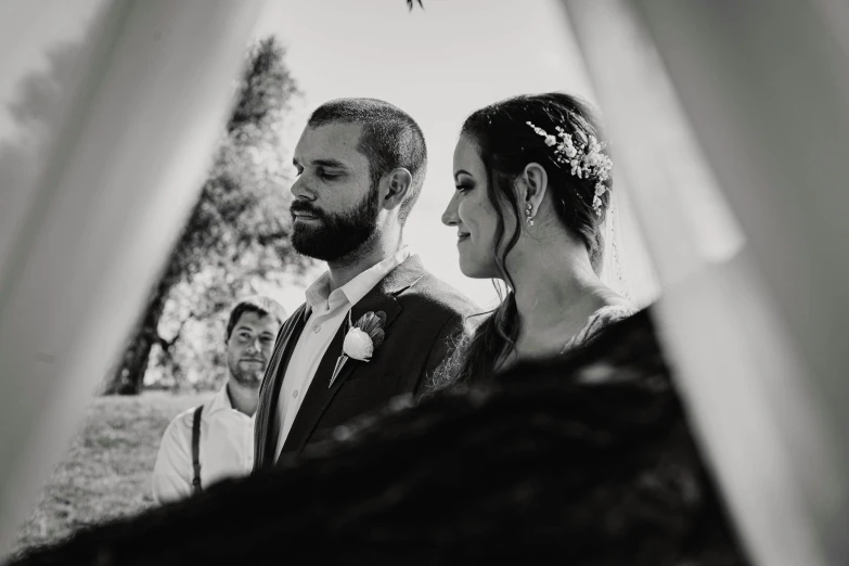 a man and woman standing underneath a white tent