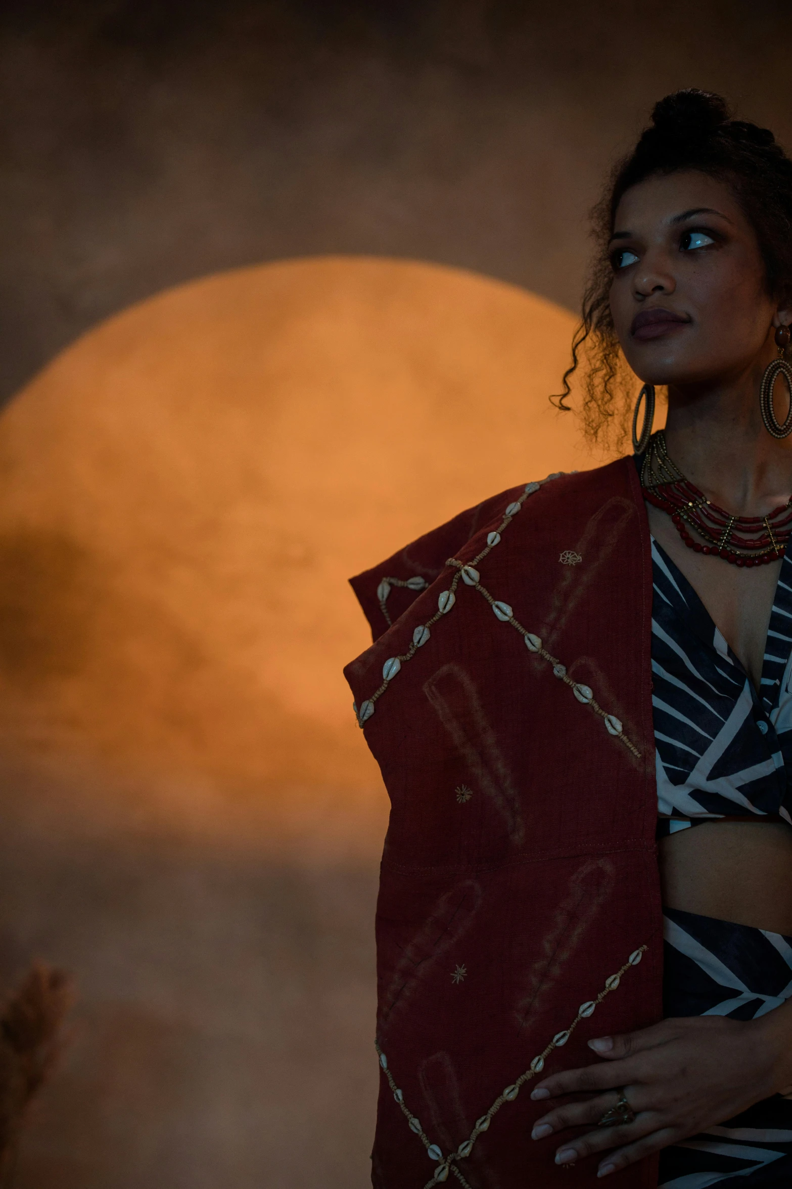 a woman is wearing a red and black sari