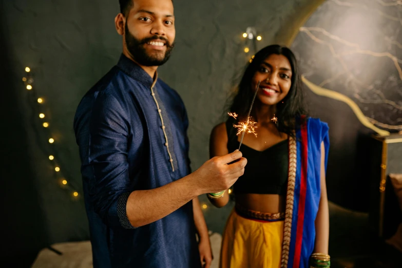 a woman in yellow is smiling and holding fireworks