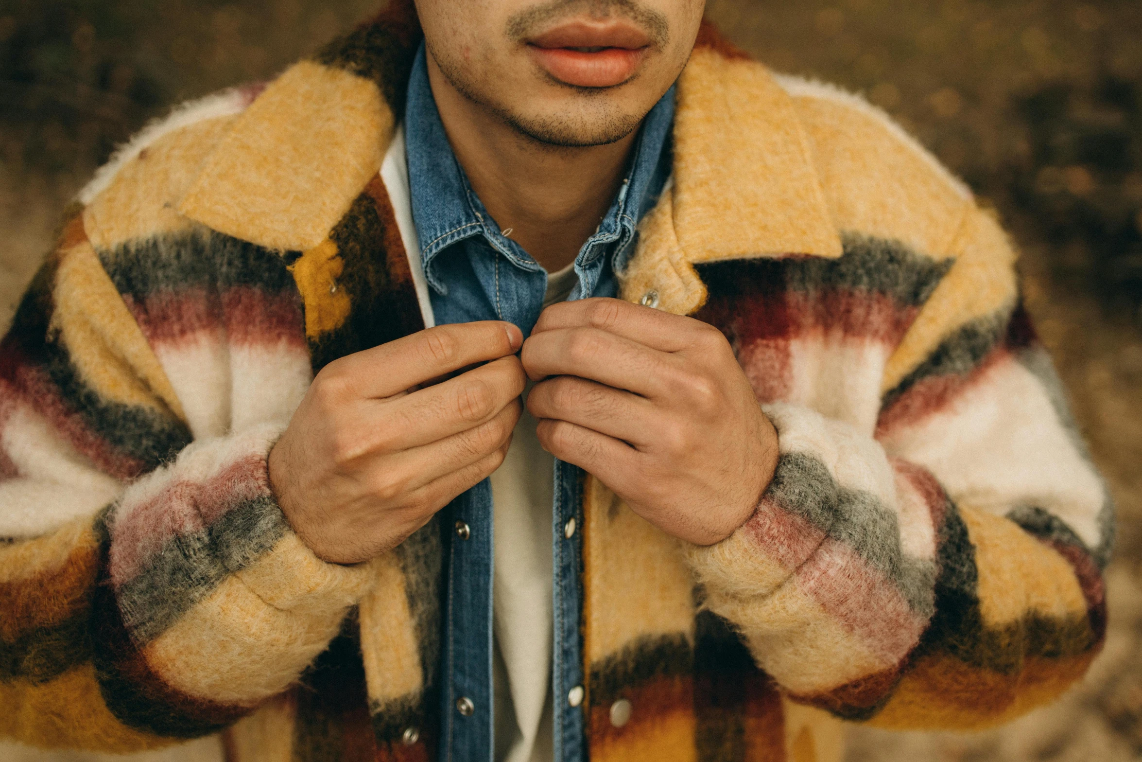 a man who is wearing a sweater and tie