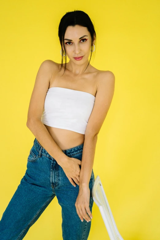 a woman posing in jeans and white top
