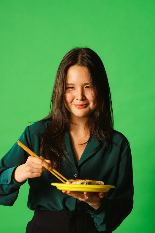 woman holding up a bowl with a pair of chopsticks and a dish