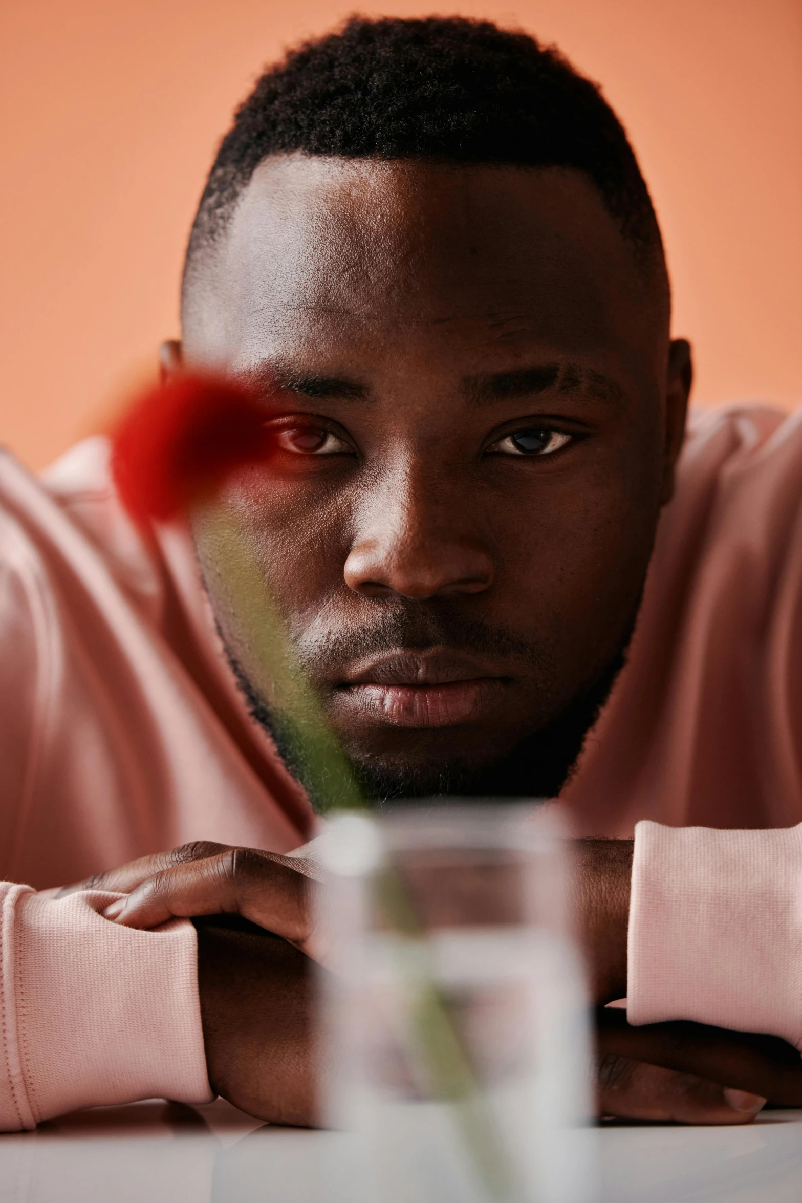 a man is looking at the camera with a flower in his hand