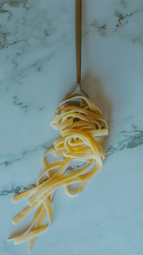 a bunch of pasta is tangled up on a wood stick